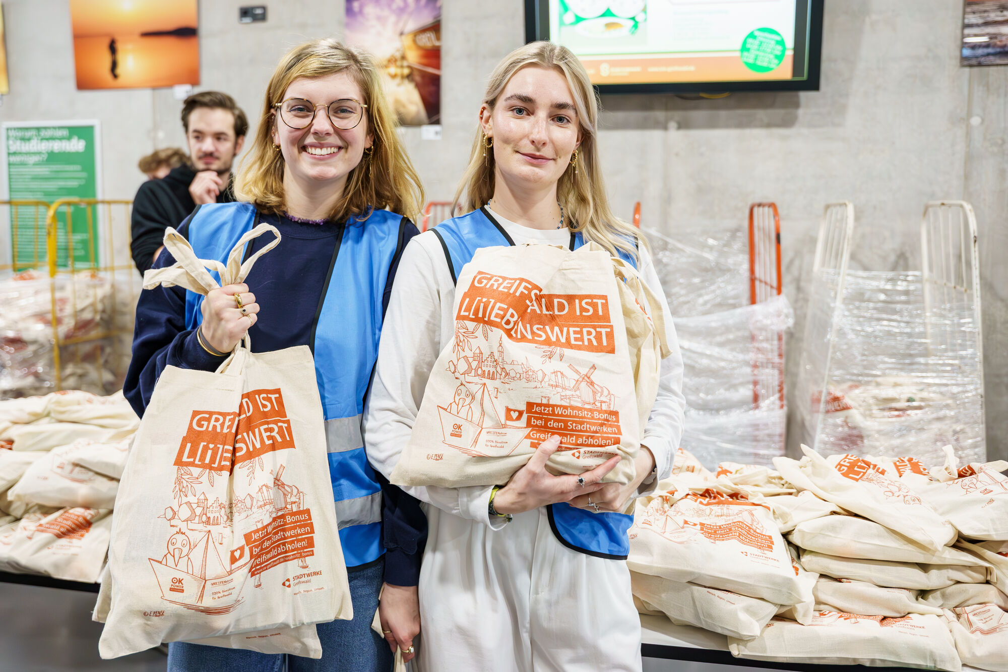 Two students presenting their welcome bags to the camera.