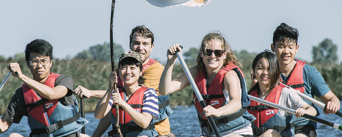 Teilnehmende der Summer School auf einem Floß auf dem Greifswalder Ryck.