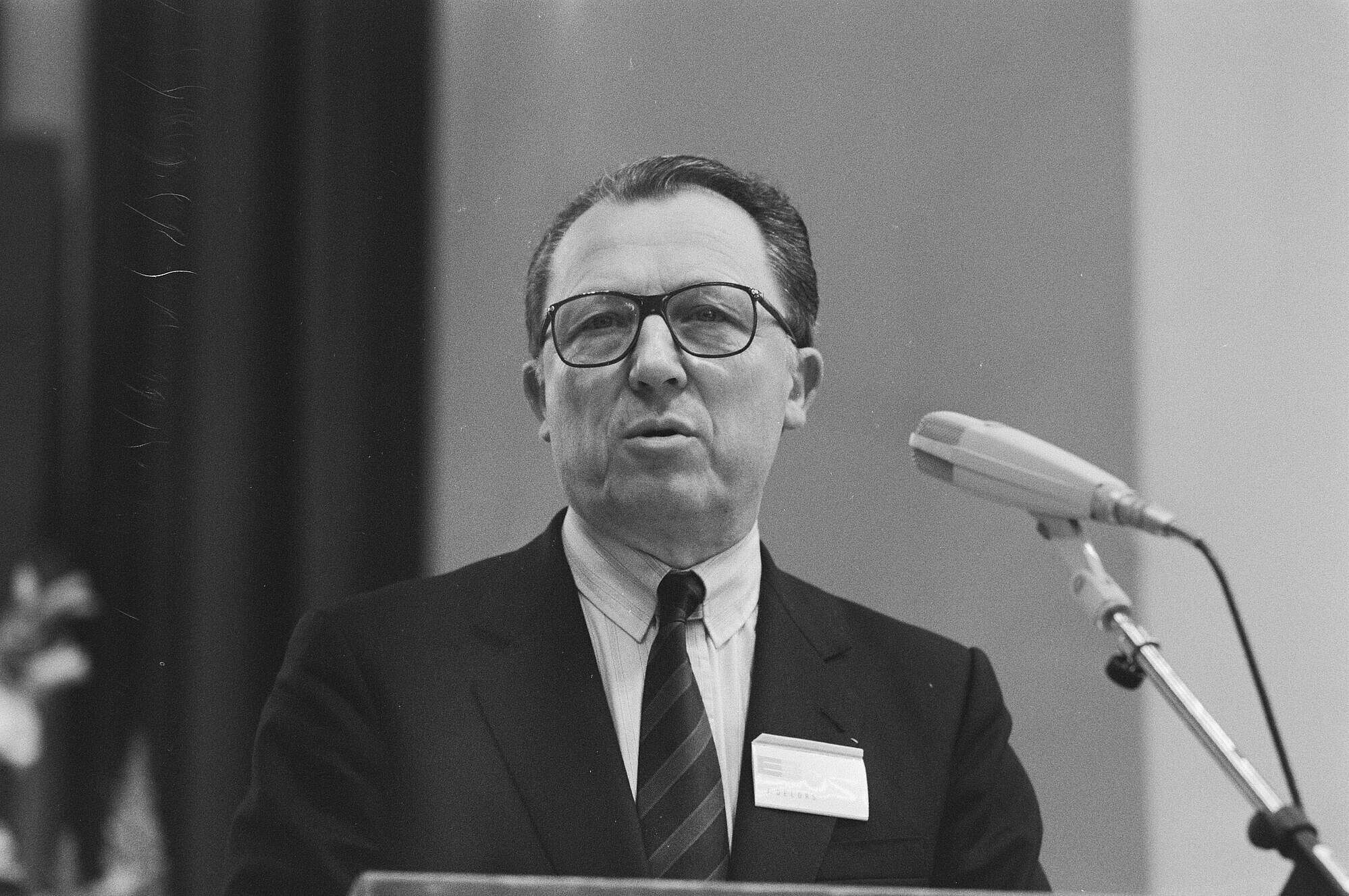 Auf dem Schwarz-Weiß-Bild ist Portrait von Jacques Delors während eine Rede zu sehen. Das Bild ist aus dem Jahr 1988 Wikimedia CC0