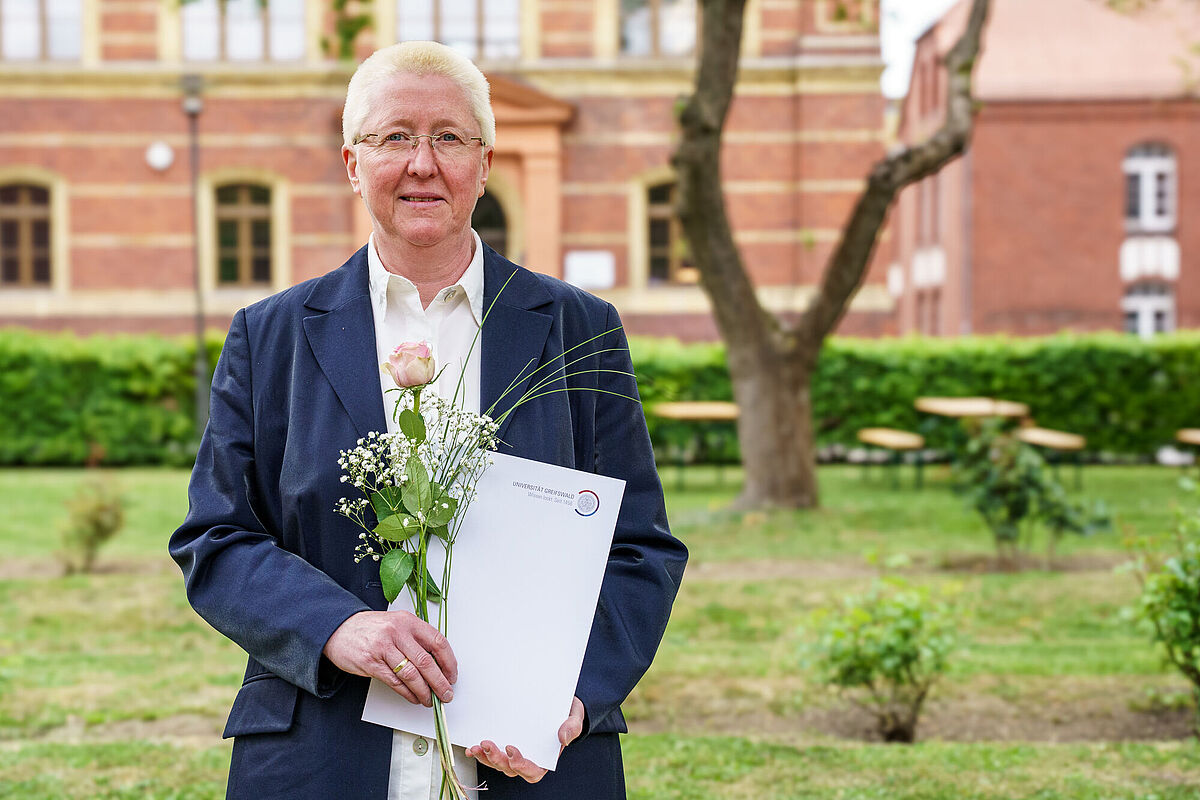 Dr. Simone Venz Dr. Simone Venz steht im begrünten Innenhof des Campus Loefflerstraße.