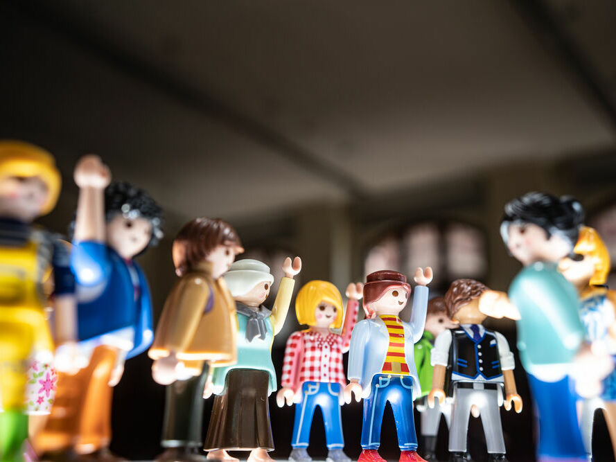 Foto: Jannik Zoubek - Symbolbild Verschwörungstheorie: Gruppe von abstimmenden Playmobil-Männchen mit erhobenen Händen, Nahaufnahme 