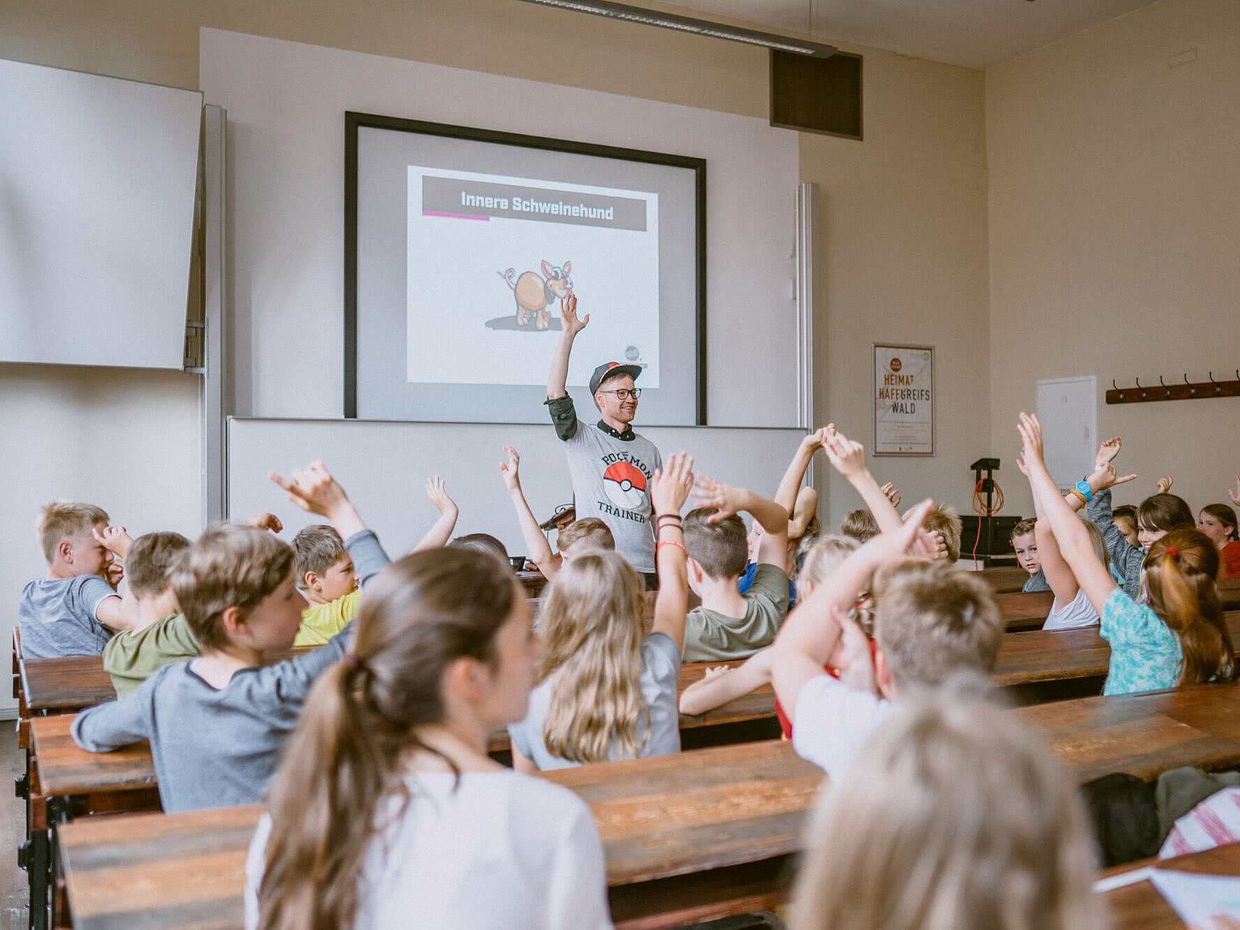 Kinder im Hörsaal, die Kindern melden sich.