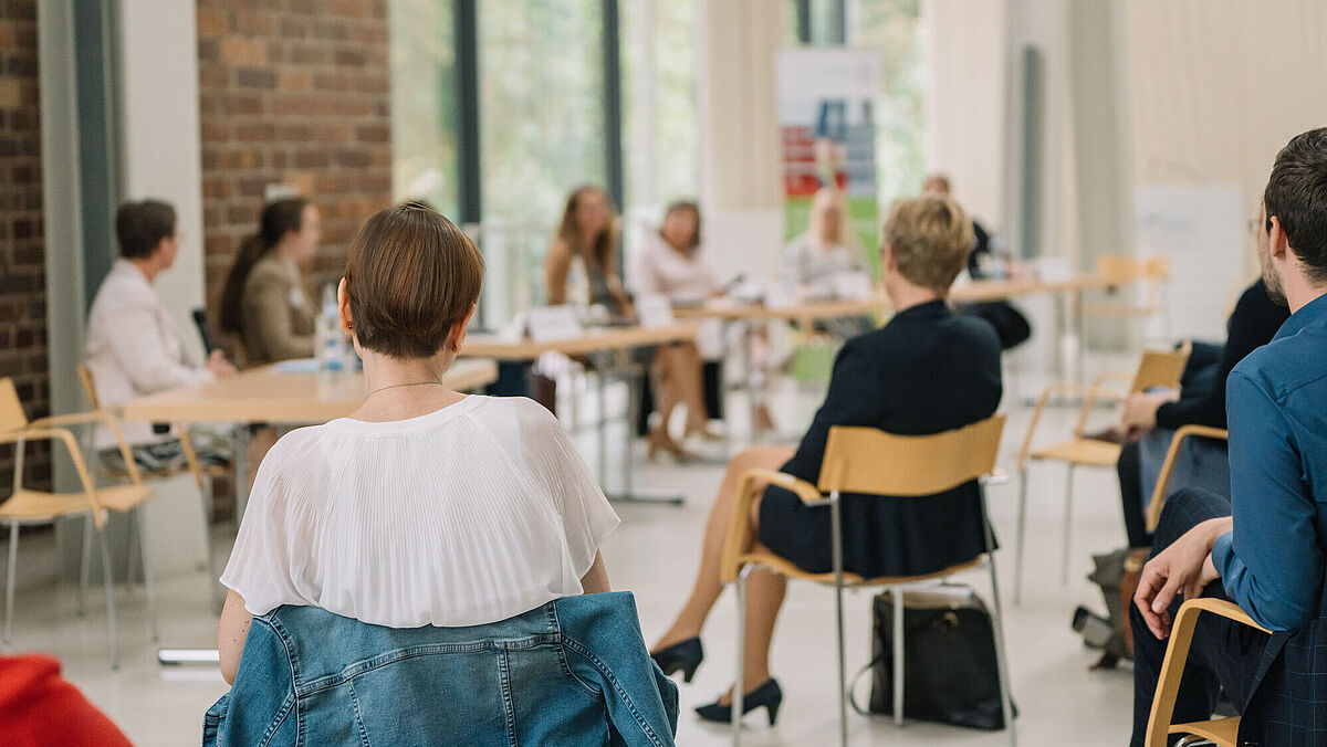 Personen sitzen beim Gesprächsforum: 100 Tage Professur und unterhalten sich