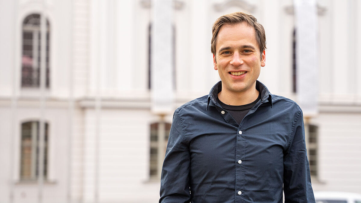 Professor Daniel Siegel steht vor dem Hauptgebäude der Universität.