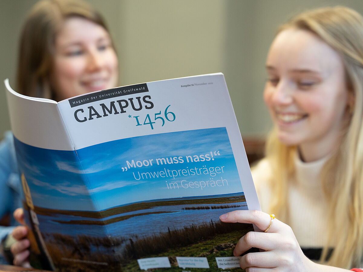 Zwei Frauen lesen im Magazin „Campus 1456“.