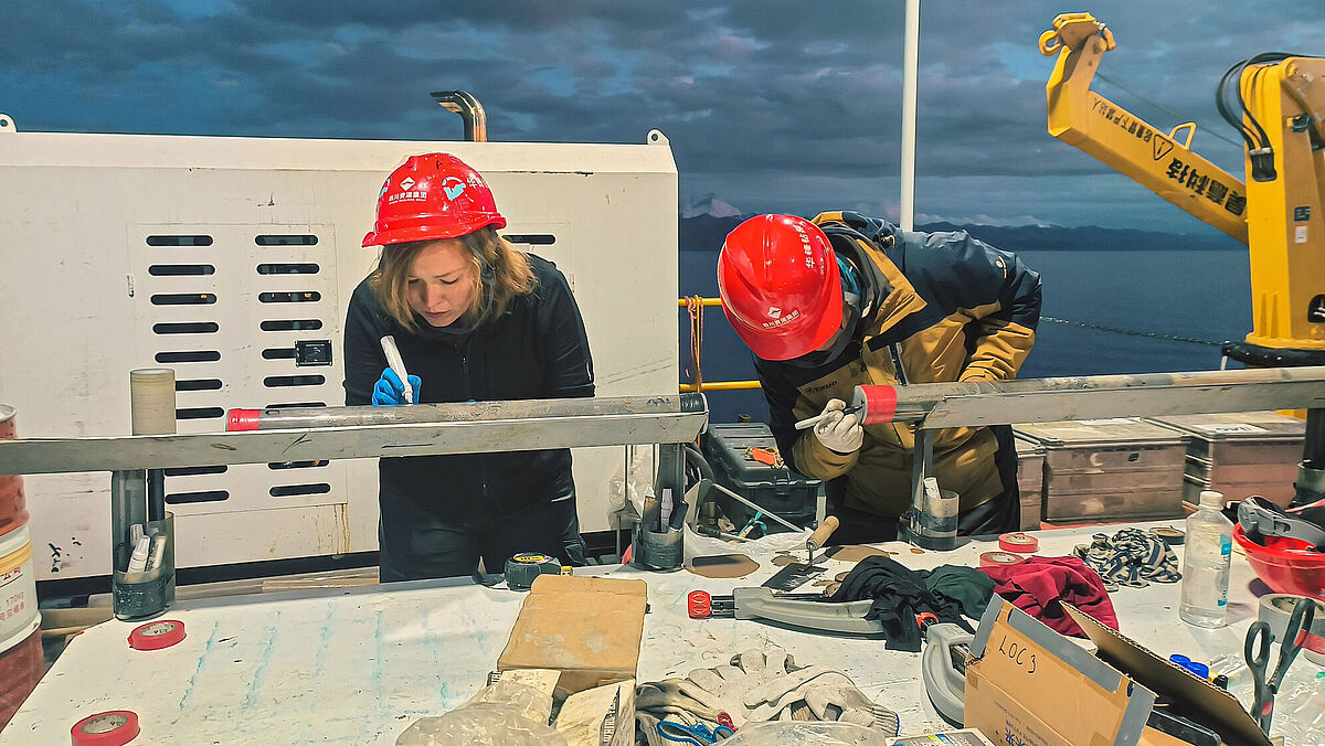 Before the sediment cores from Lake Namco can be analysed in the laboratories, they are cleaned and labelled on board of the drilling platform. © Olga Gildeeva