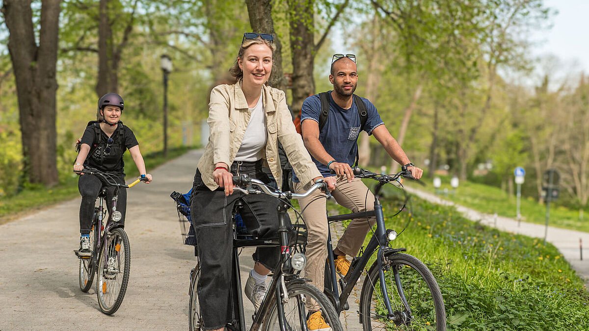 Zu sehen sind drei Fahrradfahrer*innen.