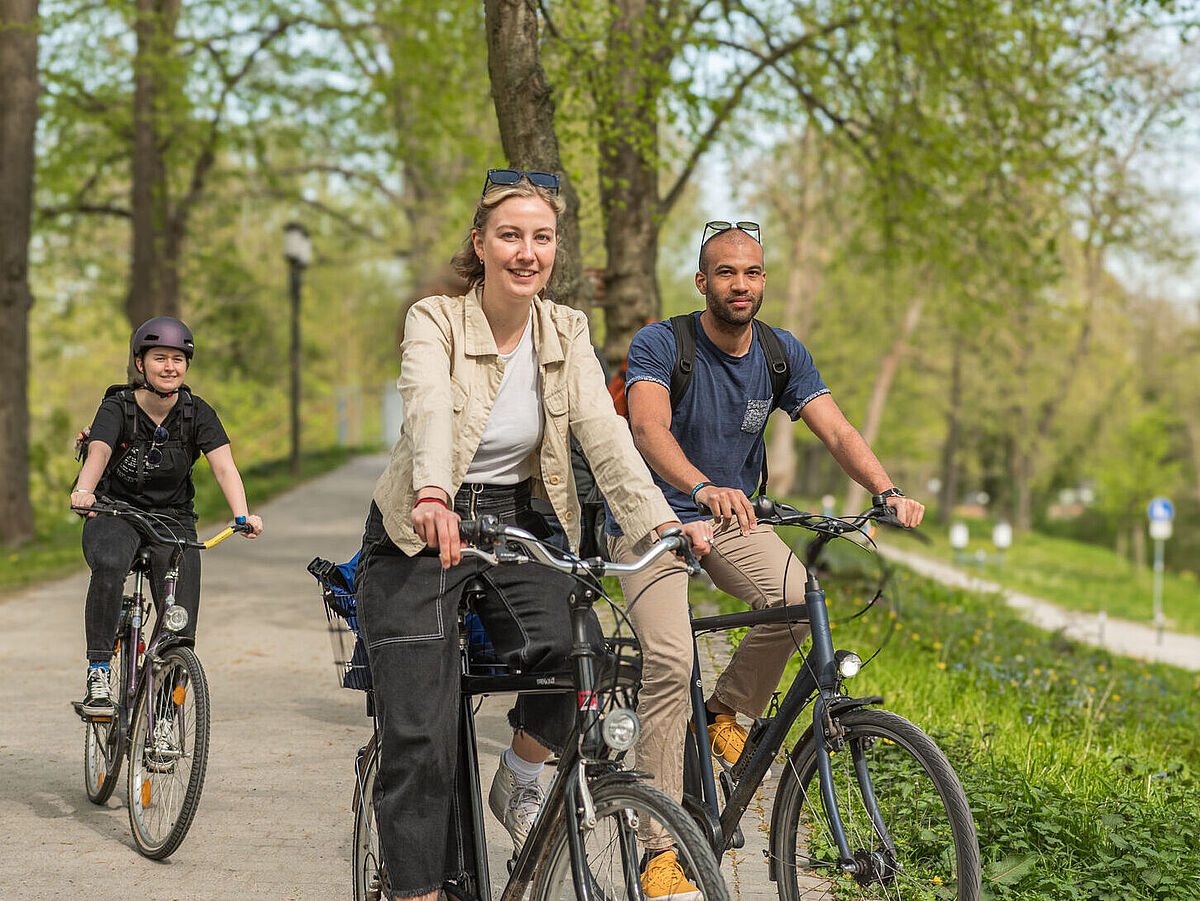 Zu sehen sind drei Fahrradfahrer*innen.