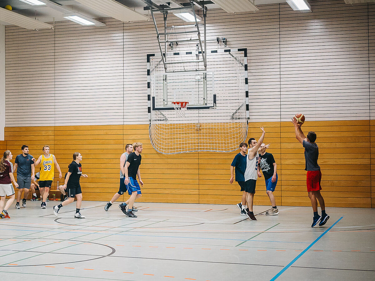 Es wird in einer Sporthalle Basketball gespielt.