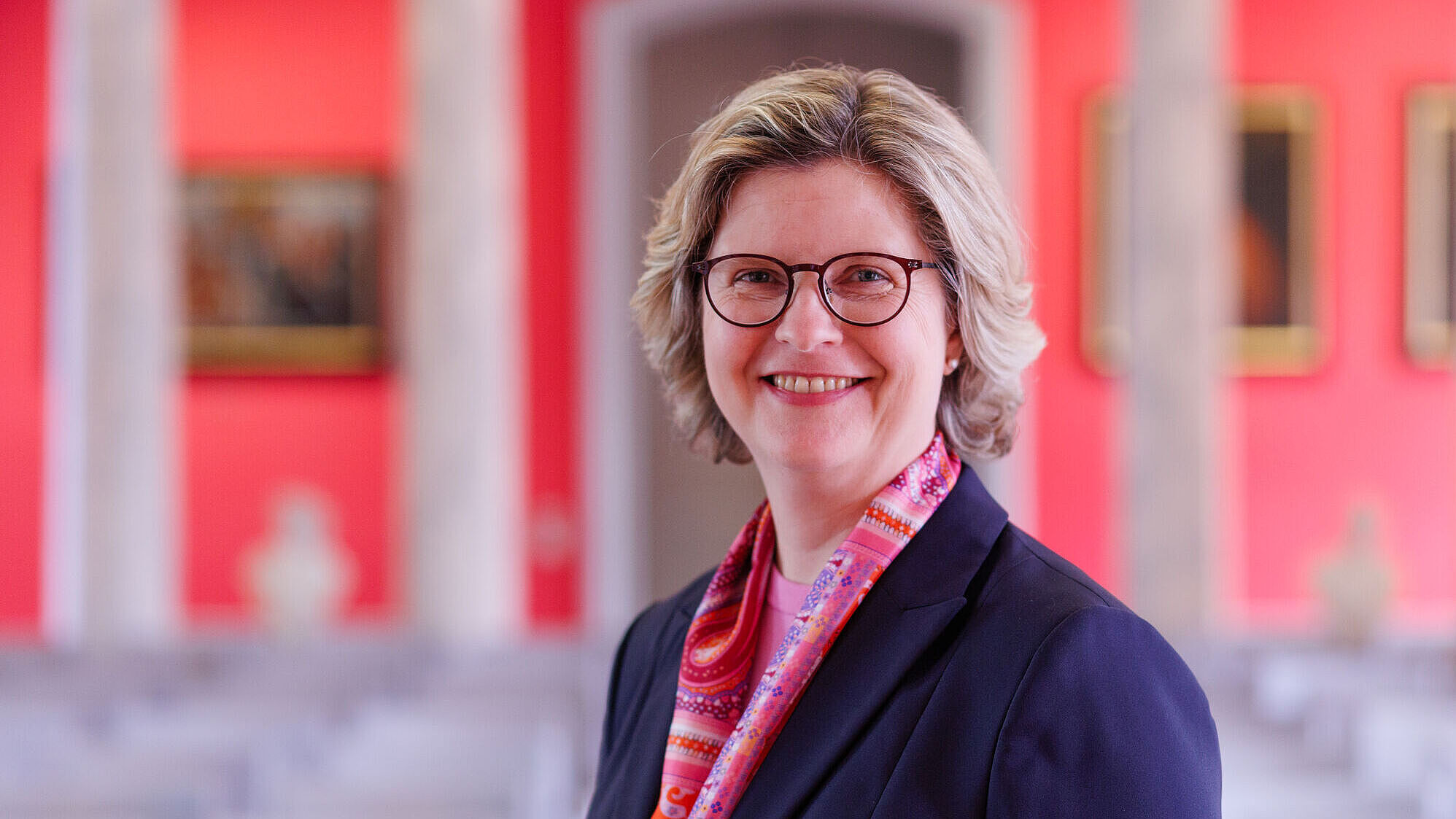 The photo is a portrait of Pro-Rector Prof. Dr. Anette Sosna in the University of Greifswald's Aula