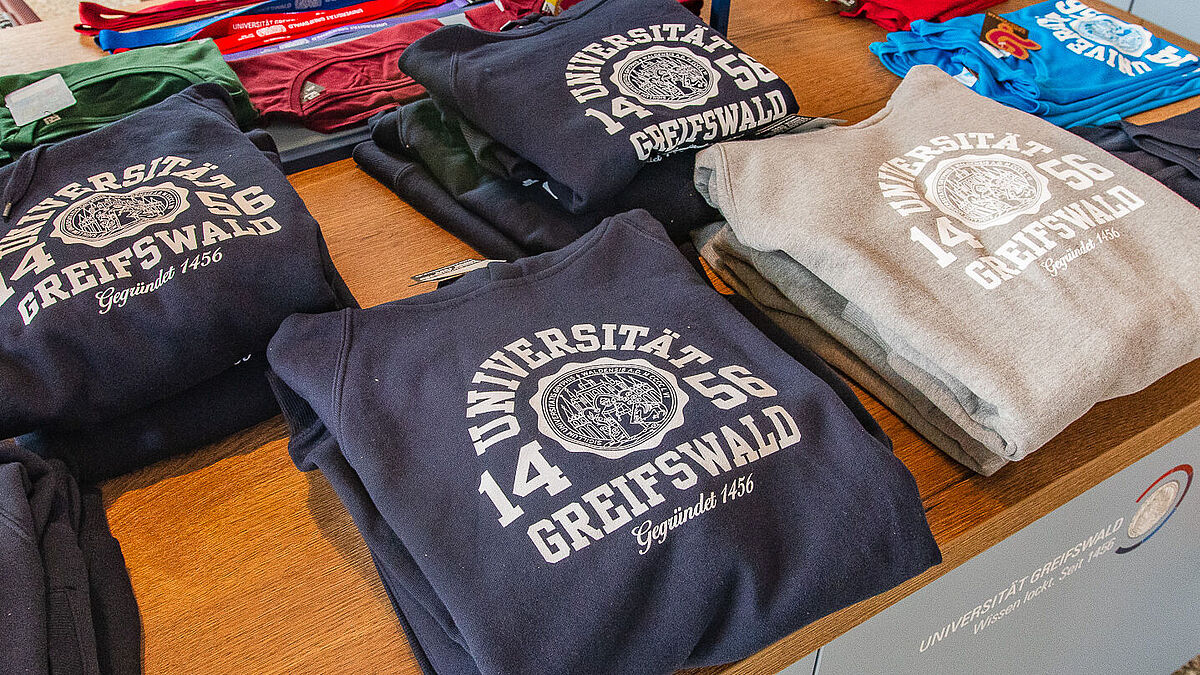 Hoodies im Uniladen in einem Regal aufgeschichtet.