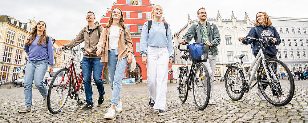 Studierende laufen über den historischen Marktplatz.