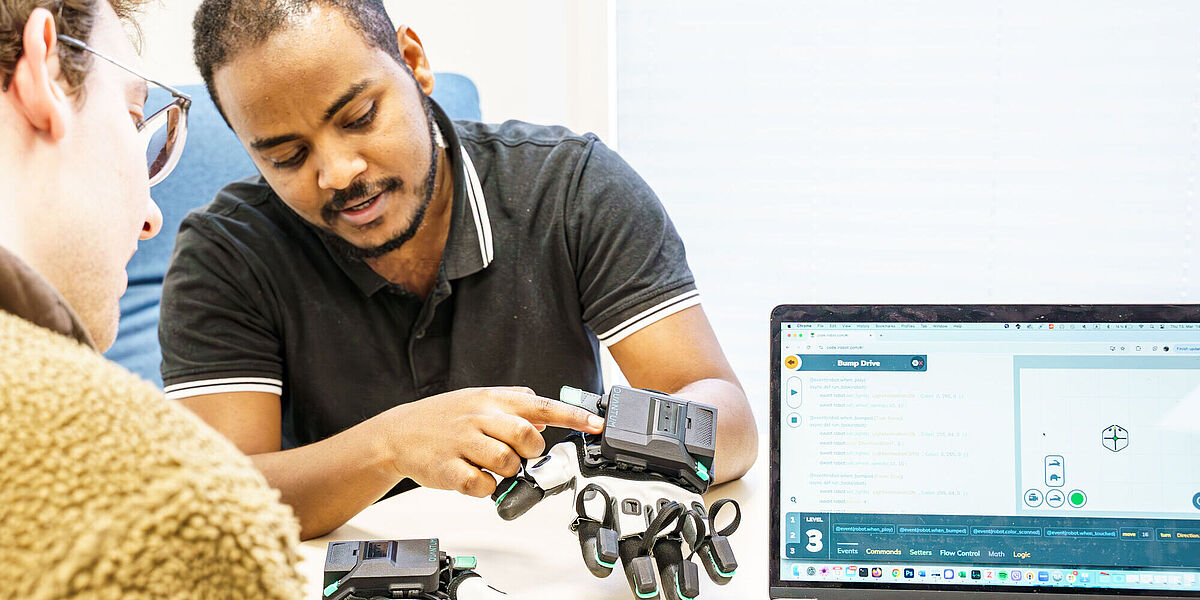 Two students from the degree course Data Science working with a sensory glove