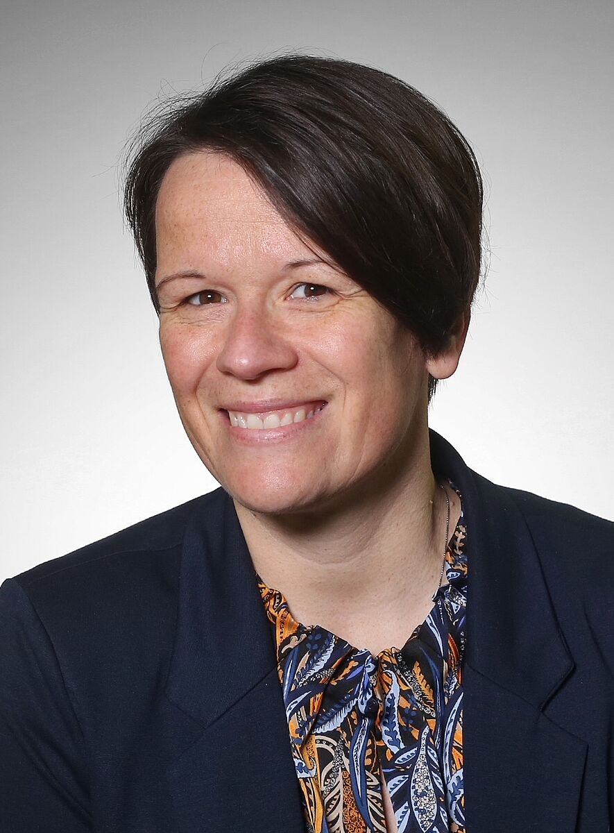 Portrait von Diana Albrecht vor grauem Hintergrund