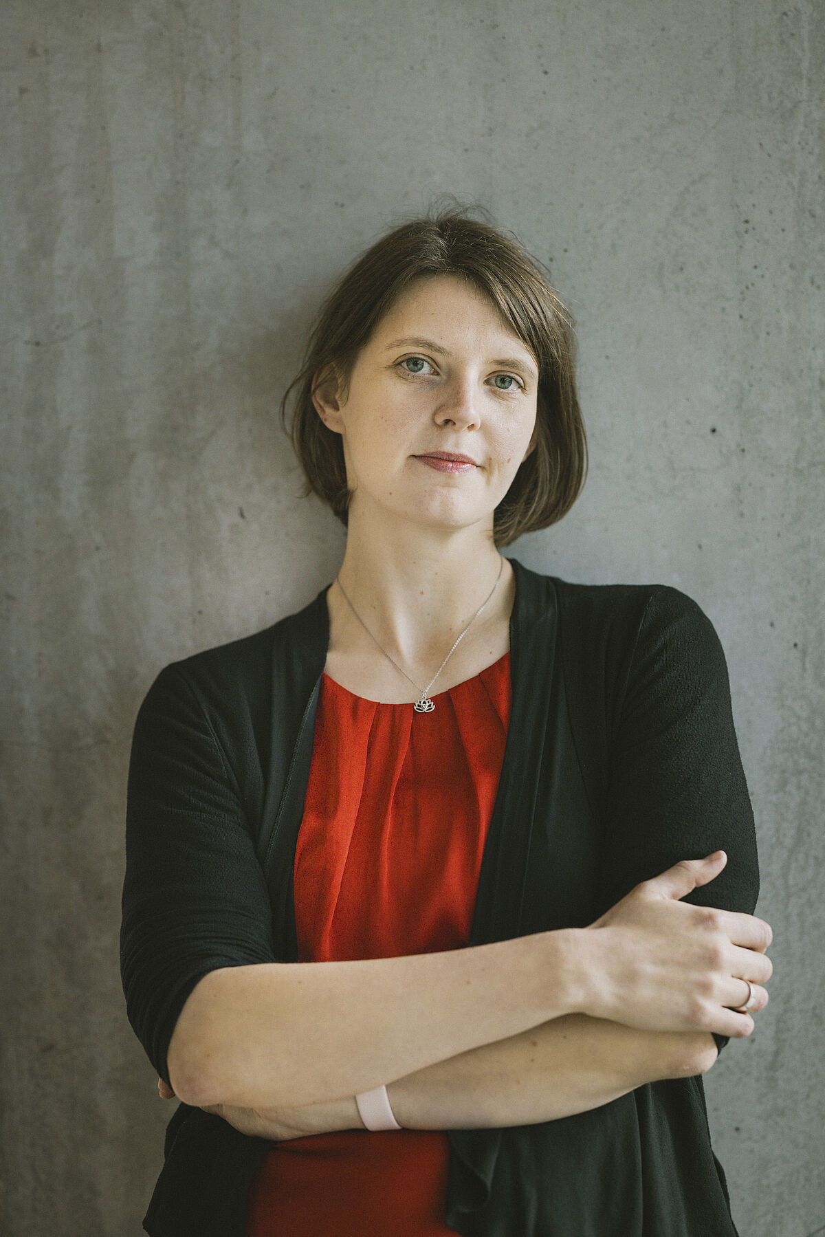 Portrait von Dr. Anica Graf. Sie verschränkt die Arme und lächelt etwas.